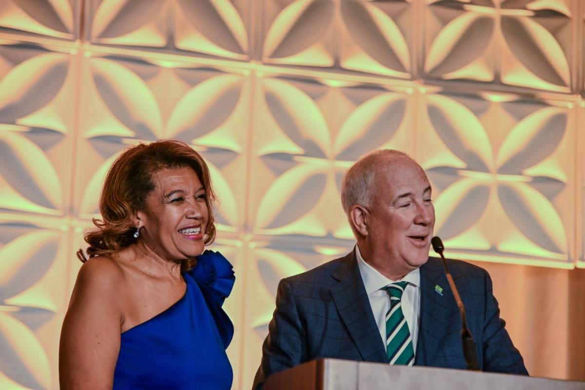 Man and woman at podium on stage at event