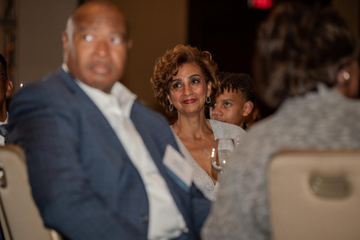 Pinkie Mayfield looking at speaker on stage while seated at event