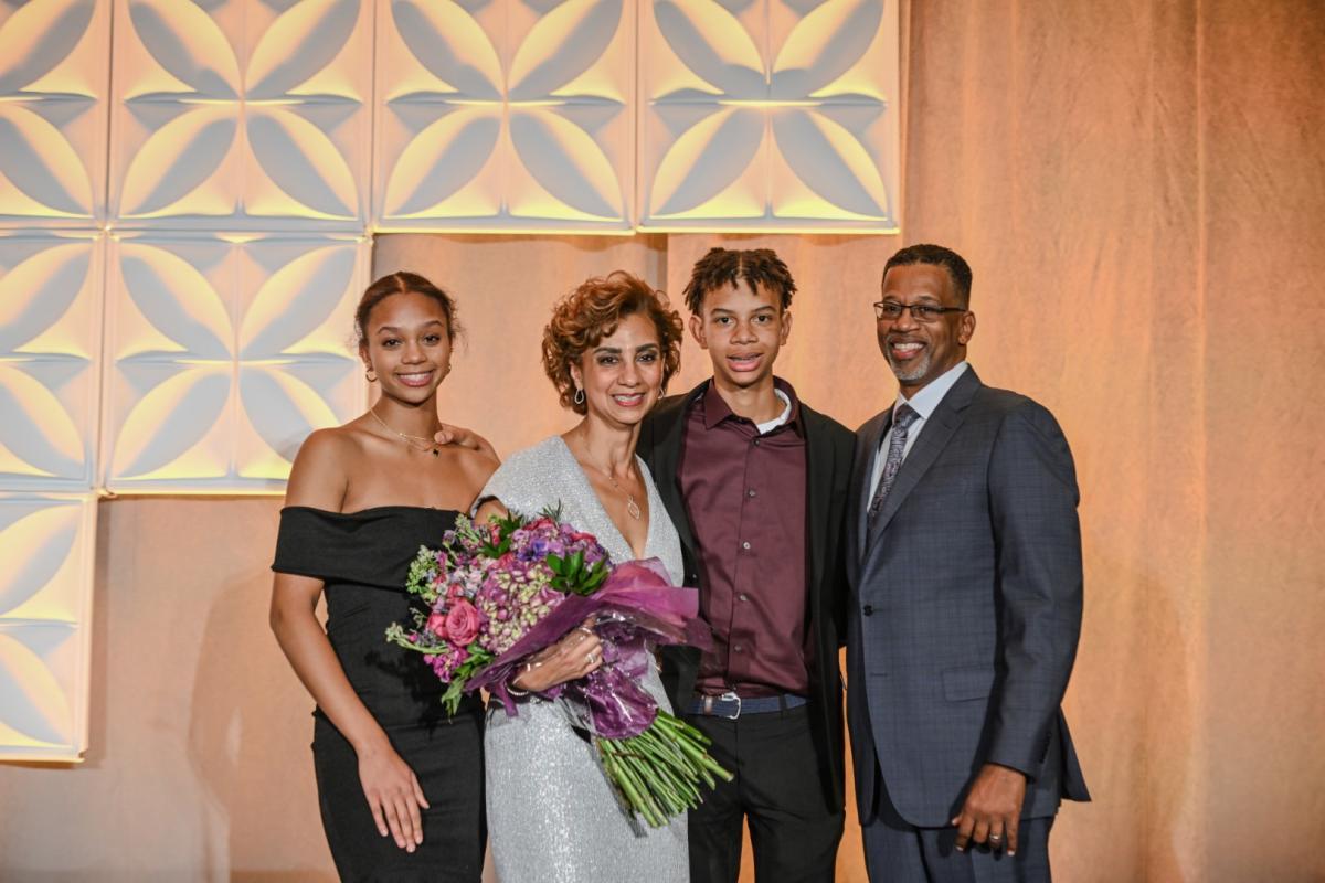 Pinkie Mayfield with her family holding flowers after accepting award